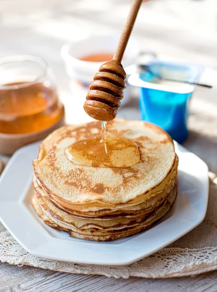 Pancakes with honey on the kitchen table — Stockfoto